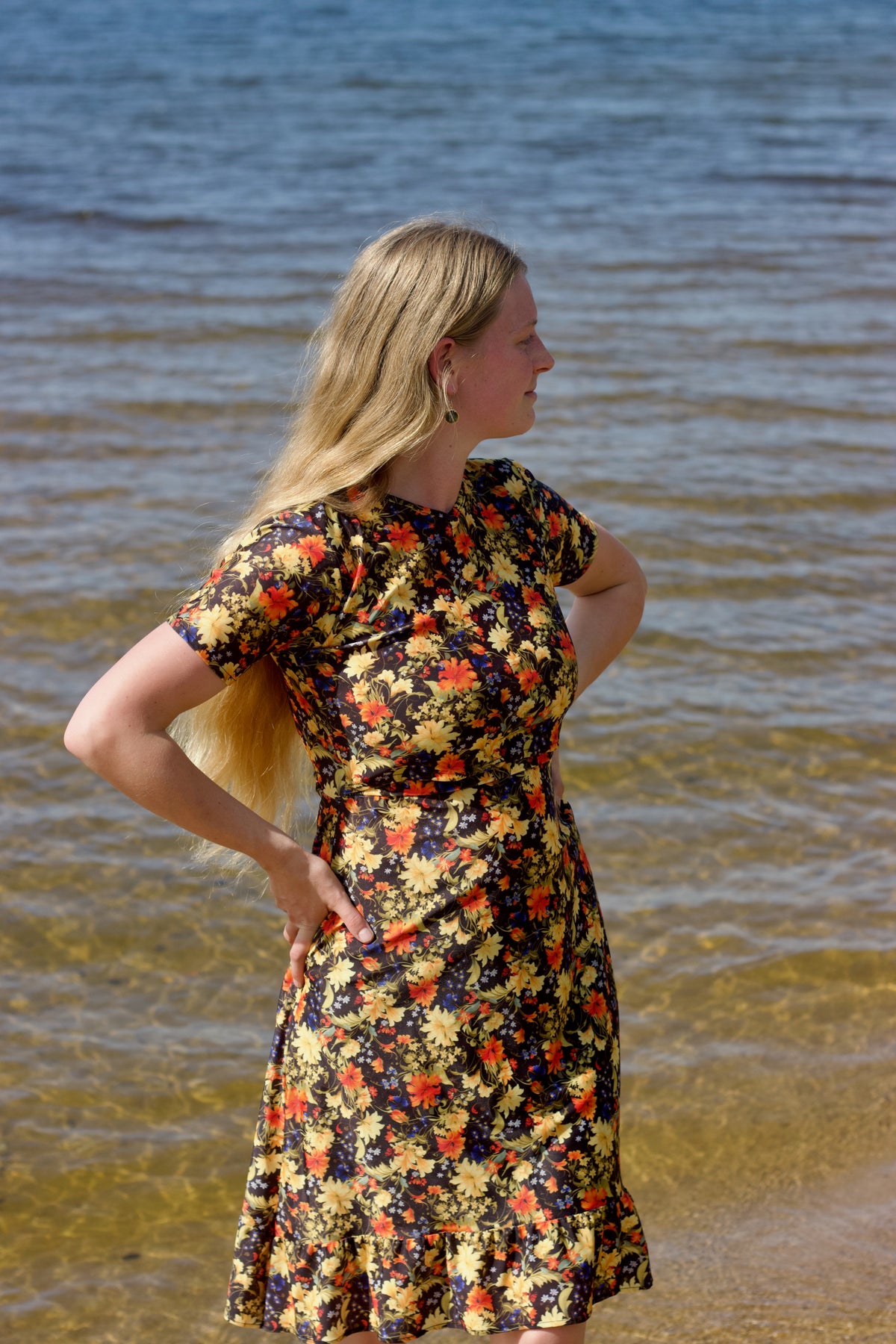 Woman in a floral christian swimdress standing by the water's.
